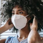 black woman putting on respirator